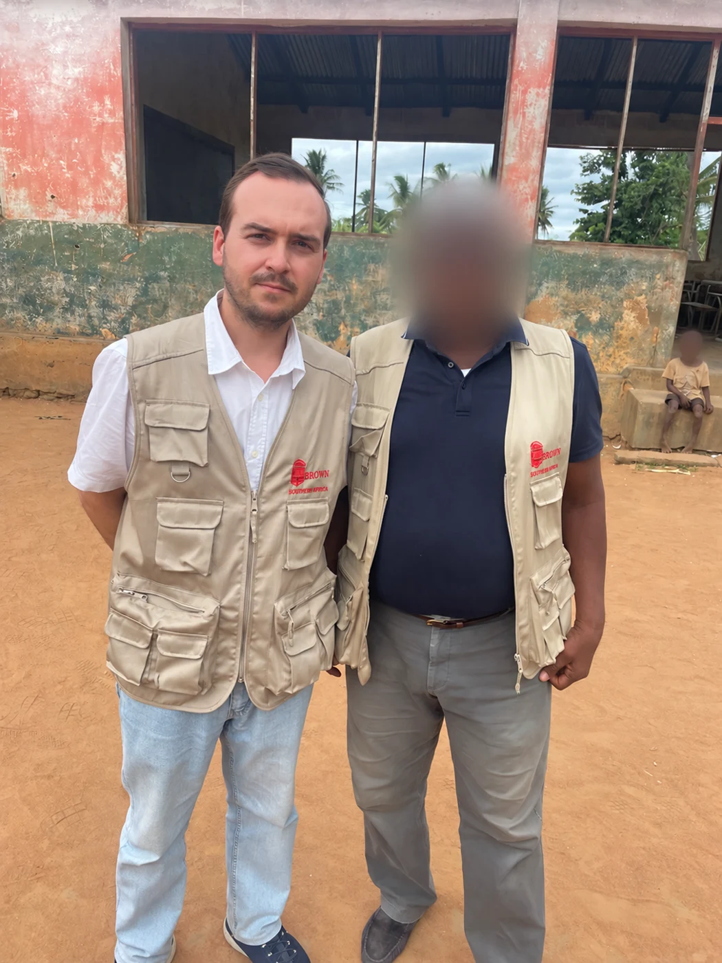 Henrique Pita Barros with a colleague in a returnees’ village, faces blurred for privacy